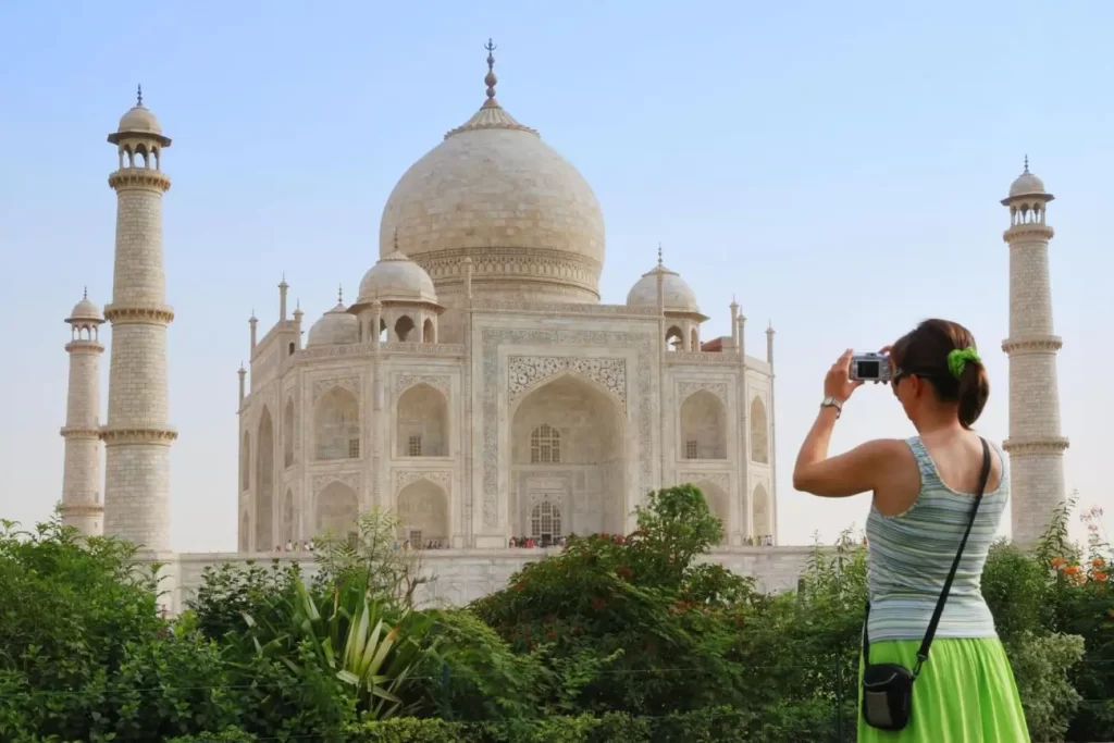 Tourist in front of Taj Mahal capturing pictures in camera