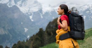 Indian girl hiking on mountain with backpack in Manali, Himachal Pradesh, India