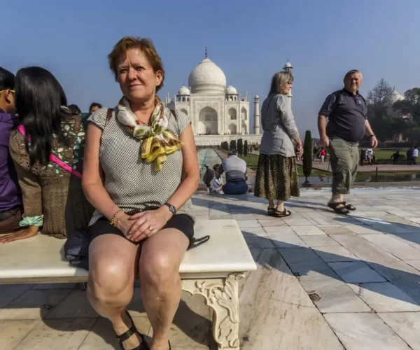 Adult tourist women posing in front of the Taj Mahal anxious to see one of the seven wonders a world heritage building symbolising love