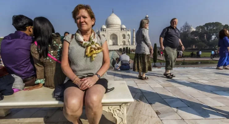 Adult tourist women posing in front of the Taj Mahal anxious to see one of the seven wonders a world heritage building symbolising love